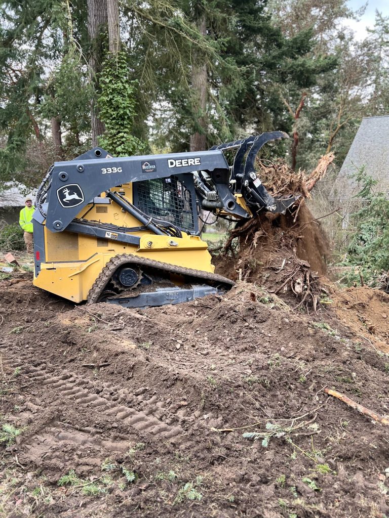 Skid steer with grapple removing a stump